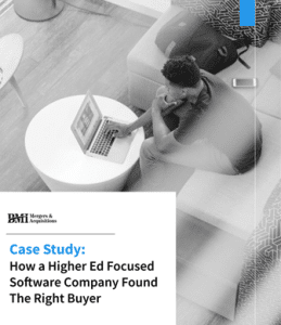 software company M&A. a person sitting in a common area on their laptop