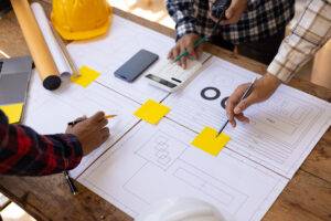 Engineers working on blueprints — concept related to M&A for architecture and engineering firms